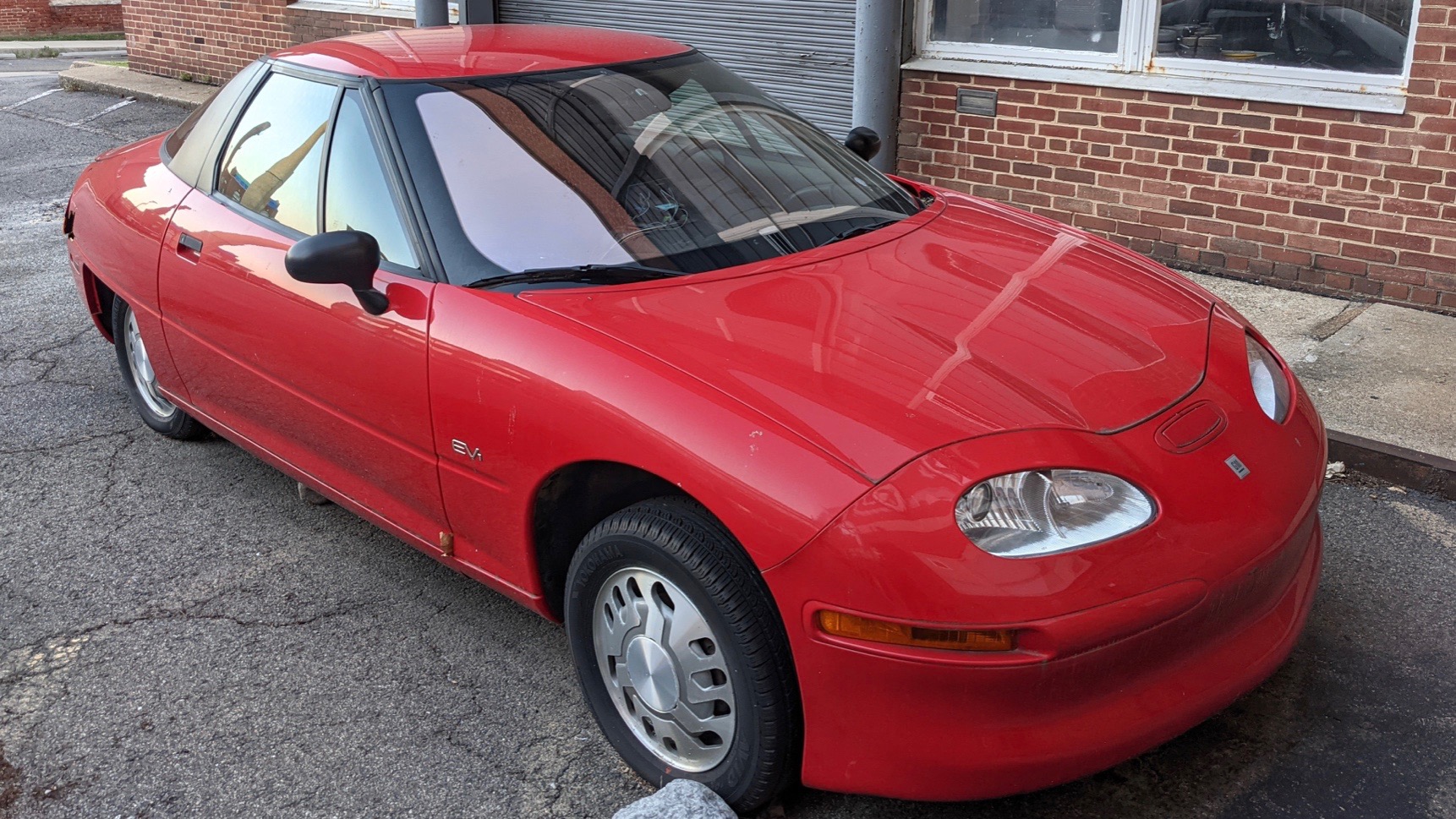 Rare GM EV1 electric car survivor converted to a hybrid, parked outsideRare GM EV1 electric car survivor converted to a hybrid, parked outside